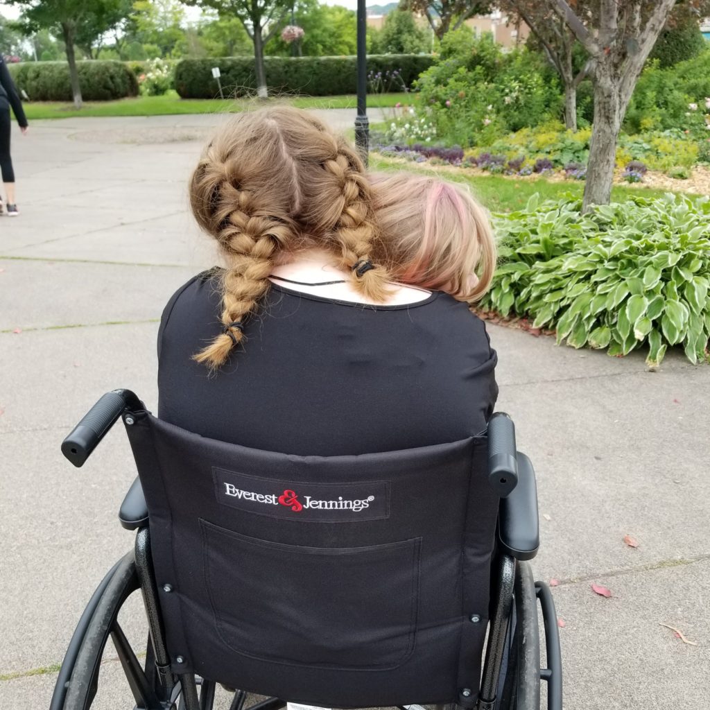 Two girls sharing a wheelchair